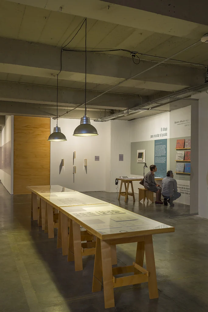 long table beneath pendant lamps — Facing the other